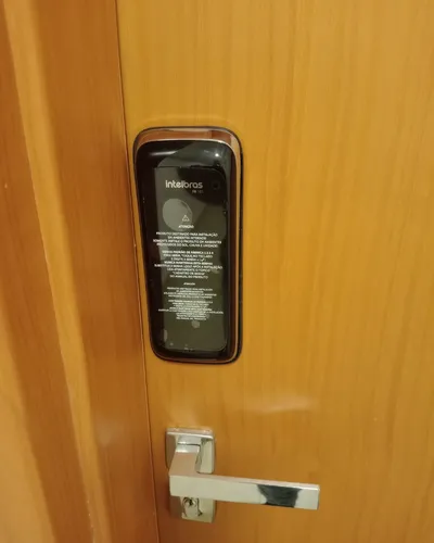 Fechadura digital Intelbras instalada em porta de madeira